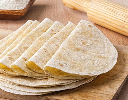 Stack of flour tortillas on a wooden surface, representing foodservice innovation