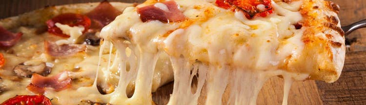 Close-up of melted cheese on pizza, representing dairy applications and ingredient solutions.