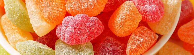 Close-up of sugar-coated gummy candies in assorted colors, representing confectionery solutions
