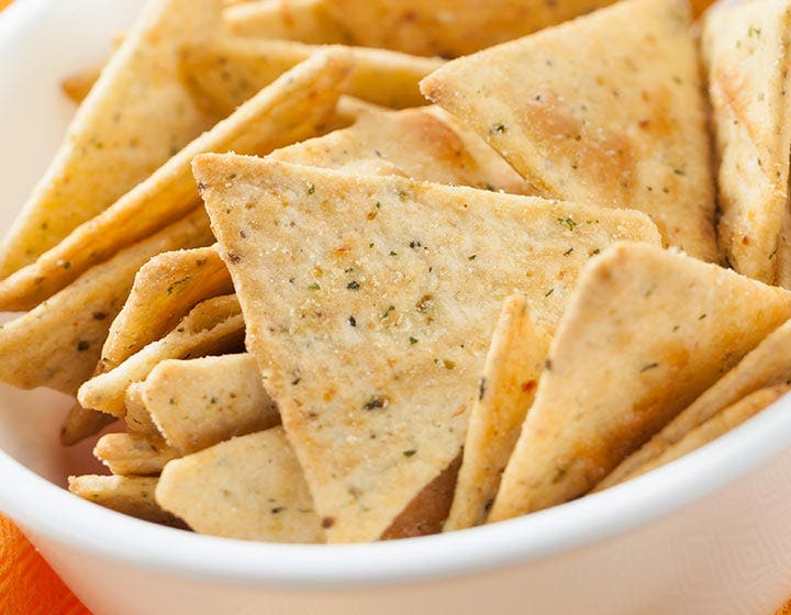 Pile of triangle baked crackers, illustrating consumer snack preferences