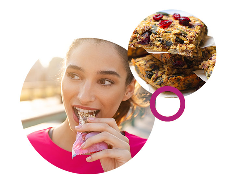 Woman eating a granola bar with nuts and seeds, representing better-for-you snack formulations